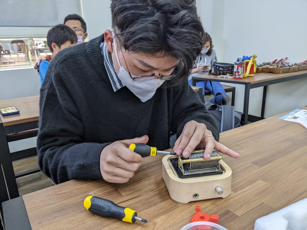 This photo recorded my participation in the Muro Box assembling class. I was doing the final step to screw its cylinder’s holder before I power on the music box to listen to its live performance!